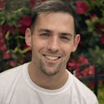 Portrait of a smiling man in front of vibrant flowers in Chicago.